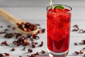 Hibiscus Iced Tea Sparkler with Fresh Mint on Wood Background